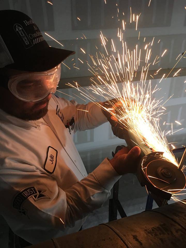 A technician working on something and sparks are flying.